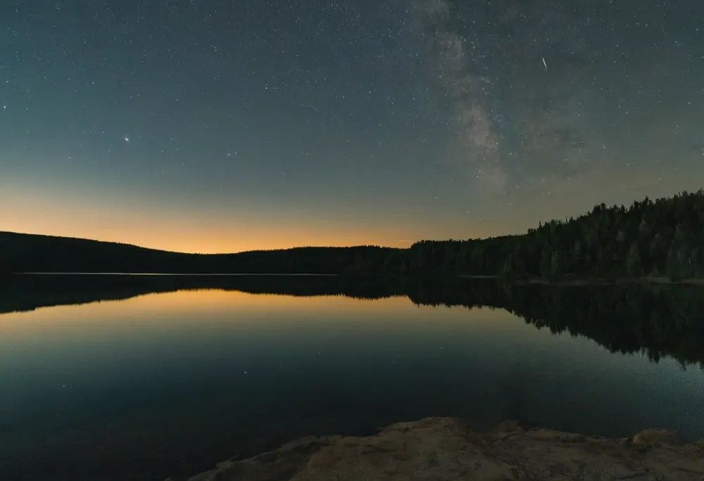 A single bright evening star over a still lake