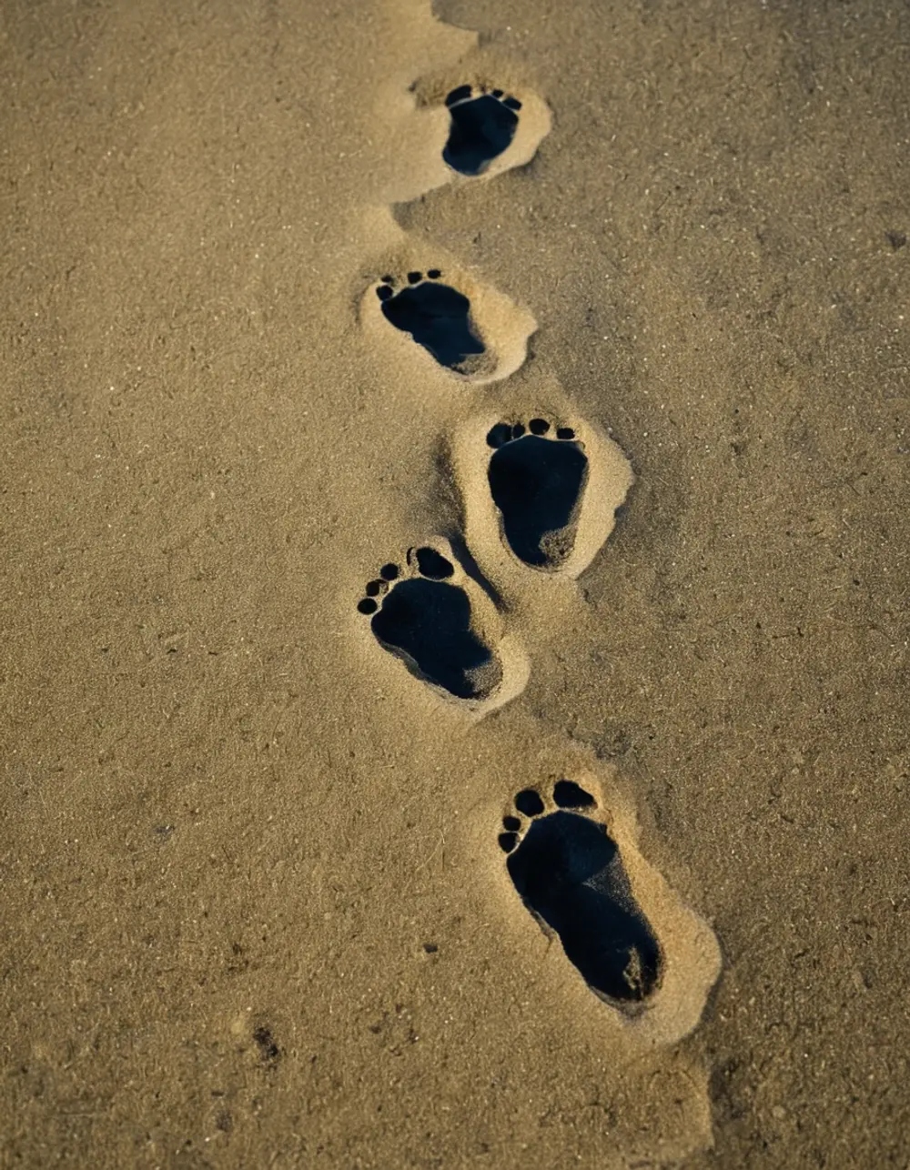 Shravana: three footprints in sand on a stone ledge at night